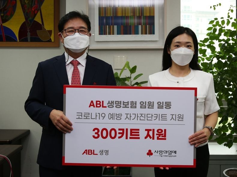 이상윤 ABL생명 인적자원실장(왼쪽)이 방성진 사랑의열매 사회공헌팀장에게 코로나19 예방 키트 300개를 전달하고 기념촬영을 하고 있다. 2021.08.23 (출처:ABL생명)