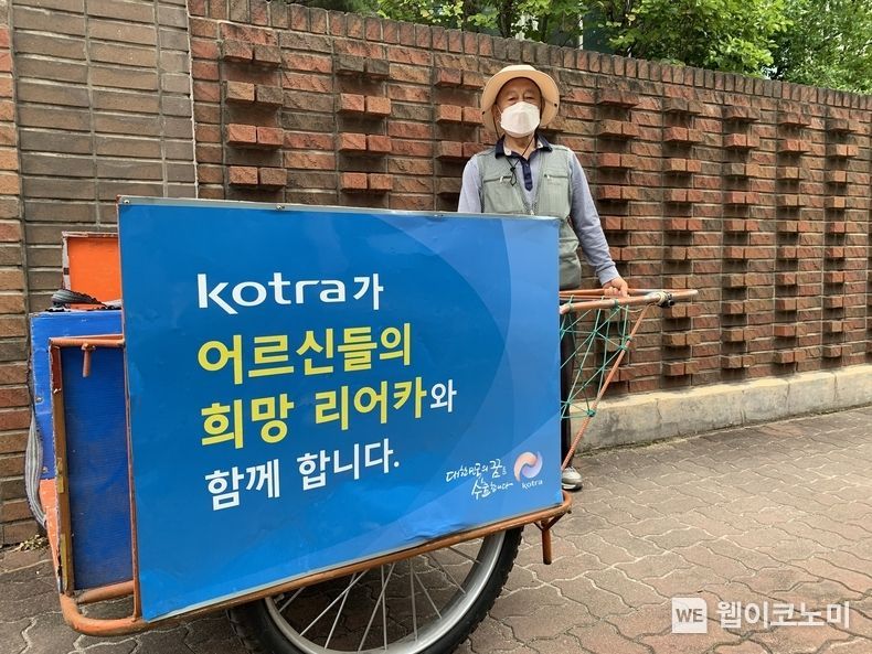폐지 수거 어르신의 리어카에 부착된 KOTRA 후원 광고 2021.10.12 (출처:KOTRA)
