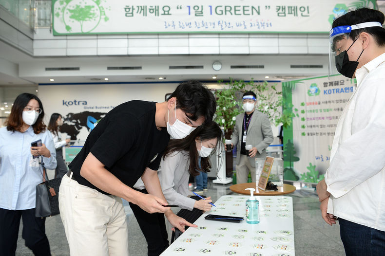 KOTRA 직원들이 ‘1일 1Green’ 친환경 실천을 서약하고 약속나무에 서약카드를 걸고 있다 2021.10.21 (출처:KOTRA)