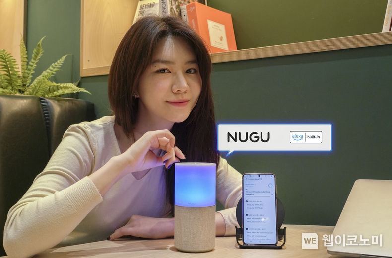 SKT 홍보 모델이 ‘누구 캔들’에서 ‘Alexa’가 탑재된 ‘누구 멀티 에이전트’ 서비스를 시연하고 있는 모습 2021.12.21 (출처:SK텔레콤)
