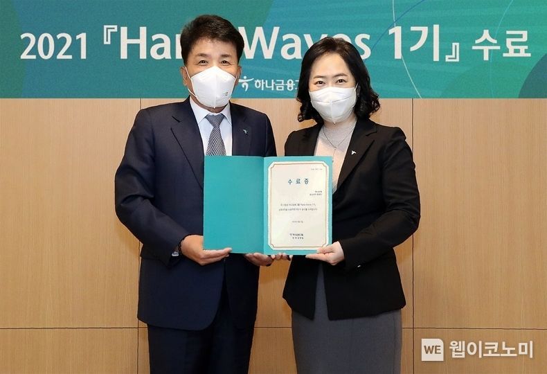 '하나 웨이브스' 1기 수료 후 함영주 하나금융그룹 ESG부회장(사진 왼쪽)이 '하나 웨이브스' 1기 대표인 홍화진 데이터&제휴투자본부 유닛리더(사진 오른쪽)와 기념촬영을 하고 있다 2021.12.23 (출처:하나금융그룹)