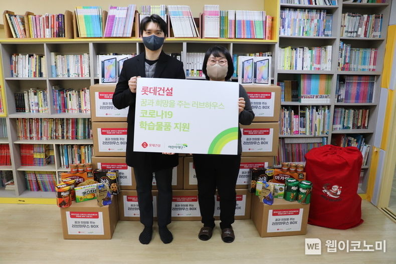 롯데건설 ESG팀 직원(왼쪽)과 꿈나래 지역아동센터 김명화 센터장(오른쪽)이 함께 기념촬영을 하고 있다 2021.12.27 (출처:롯데)