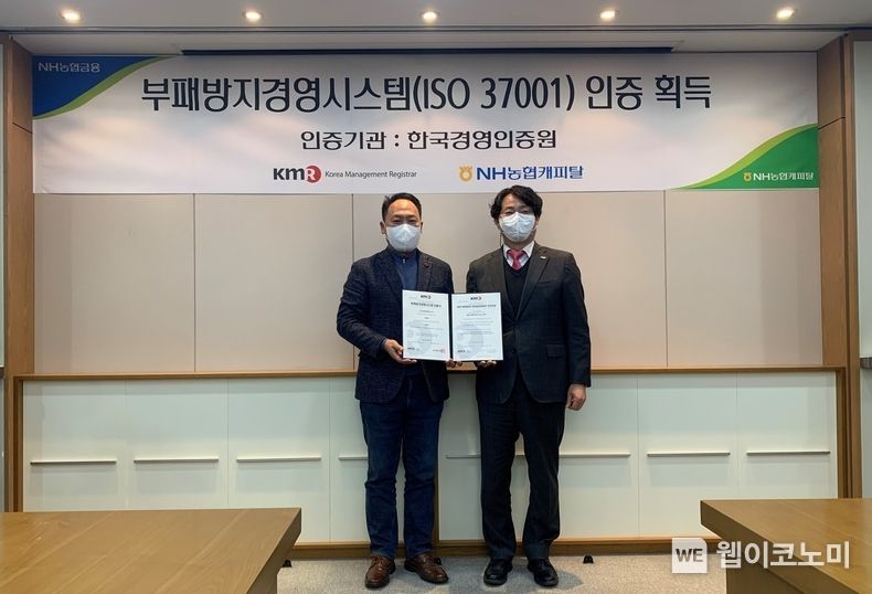 NH농협캐피탈은 21일, 공인인증기관인 한국경영인증원(KMR)으로부터 여전업계 최초로 부패방지경영시스템(ISO37001) 인증을 획득했다고 밝혔다. 박태선 NH농협캐피탈 대표이사(왼쪽)와 이영찬 한국경영인증원 상무(오른쪽)가 수여식 후 기념촬영을 하고 있다. 2022.01.21 (출처: NH농협캐피탈)
