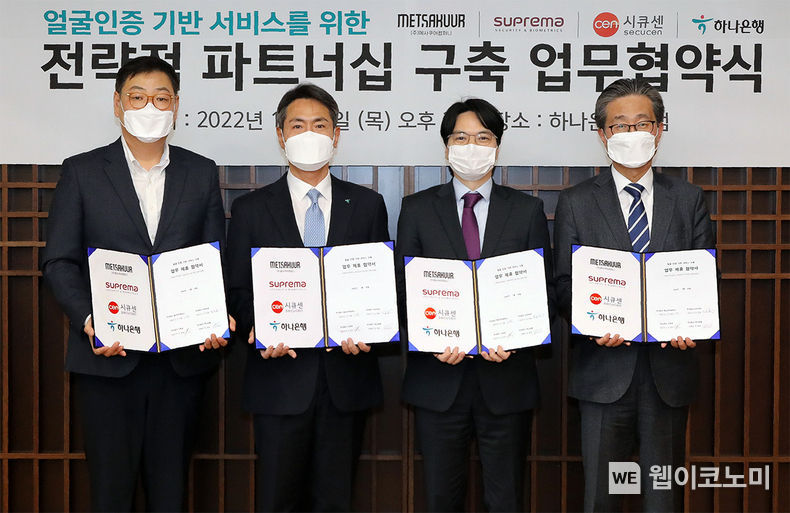 하나은행(은행장 박성호)은 지난 20일 오후 서울 중구 을지로 본점에서 ㈜메사쿠어컴퍼니(대표이사 이지훈), ㈜슈프리마(대표이사 김한철), ㈜시큐센(대표이사 이정주)과 『얼굴인증 기반 서비스를 위한 전략적 파트너십 구축 업무협약』을 체결했다고 밝혔다. 이날 협약식에 참석한 임영호 하나은행 디지털리테일그룹 부행장(사진왼쪽에서 두번째)은 이지훈 ㈜메사쿠어컴퍼니 대표이사(사진왼쪽에서 첫번째), 김한철 ㈜슈프리마 대표이사(사진왼쪽에서 세번째), 이정주 ㈜시큐센 대표이사(사진왼쪽에서 네번째)와 함께 협약서를 들고 기념촬영을 하고 있다. 2022.01.21 (출처: 하나은행)