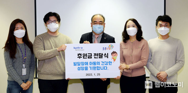 손수득 KOTRA 부사장(가운데)과 박철준 돌봄드림 이사(왼쪽에서 2번째)가 후원금 전달식 후 직원들과 기념 촬영을 하고 있다. 2022.01.26 (출처: KOTRA)