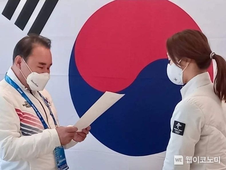 윤홍근 선수단장(왼쪽, 제너시스BBQ 그룹 회장)이 대통령 축전을 읽고 최민정 선수(오른쪽)에게 전달하고 있다. 2022.02.14. (출처: 제너시스 BBQ)
