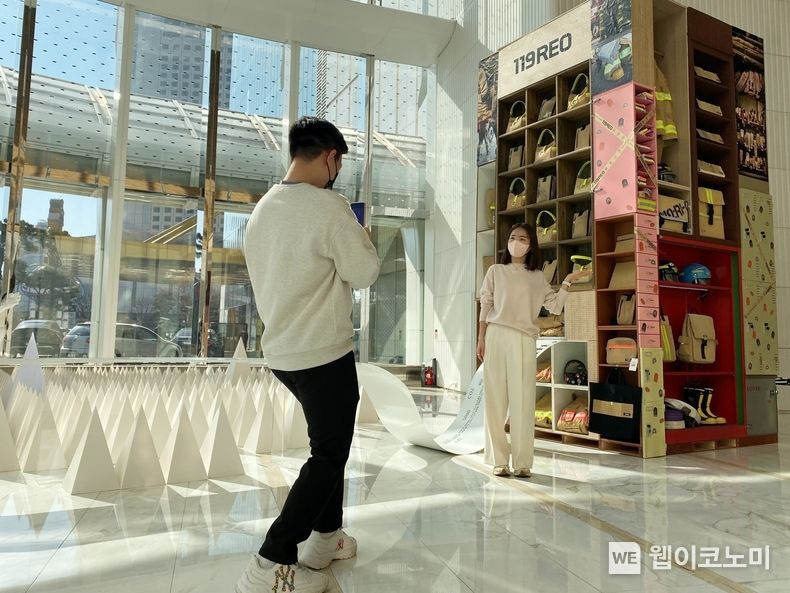  2월 24일, 서울 송파구 잠실 롯데월드타워 1층에 위치한 '어바웃 프로젝트라운지'에서 고객이 작품 및 '119레오' 상품을 구경하는 모습 2022.02.24 (출처: 롯데온)
