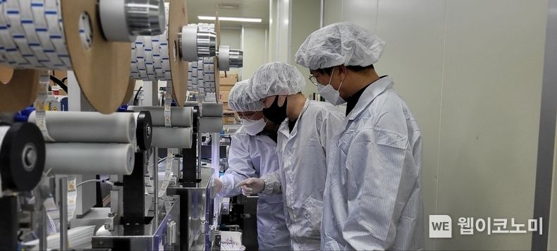 충남 천안에 위치한 자가진단키트 생산업체 '젠바디'에서 삼성전자 스마트공장 전문가와 젠바디 직원(가운데)이 자가진단키트 조립 라인을 점검하고 있다. 2022.02.24 (출처: 삼성전자)