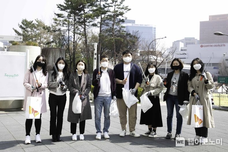 SK지오센트릭 나경수 사장(왼쪽 네번째)과 신입사원들이 서울로 주변에서 폐플라스틱 등 쓰레기를 줍는 플로깅을 한 뒤 기념사진을 촬영하고 있다. 2022.04.06 (출처: SK지오센트릭)
