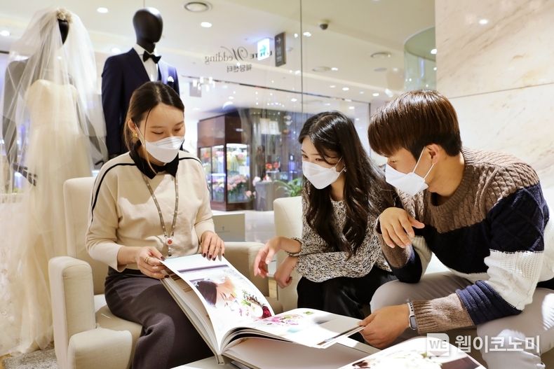 예비 신혼부부 2명이 롯데백화점 본점 웨딩센터에서 상담을 듣는 모습 2022.04.18 (출처: 롯데백화점)