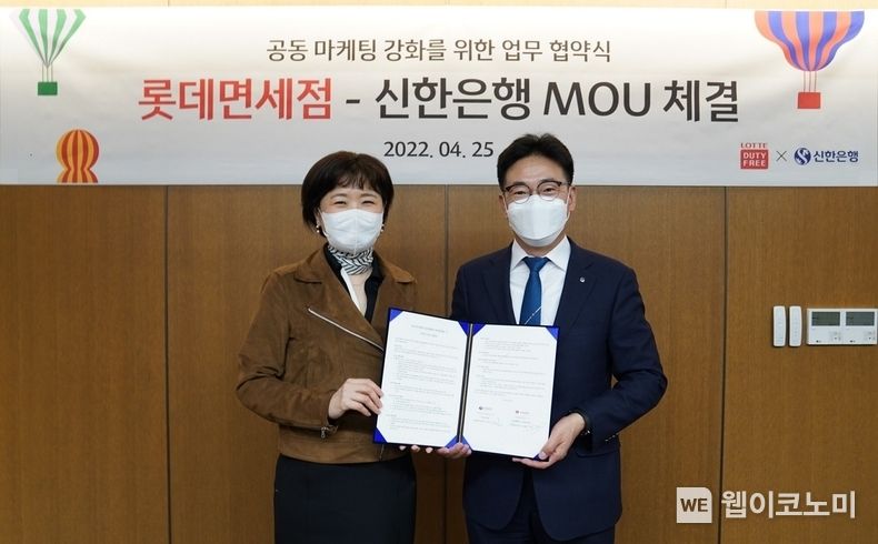 25일 서울시 중구 소재 롯데면세점 명동 본점에서 진행된 업무협약식에서 신한은행 김민수 외환본부장이(오른쪽) 롯데면세점 이상진 마케팅부문장과 기념촬영 하는 모습 2022.04.26 (출처: 신한은행)