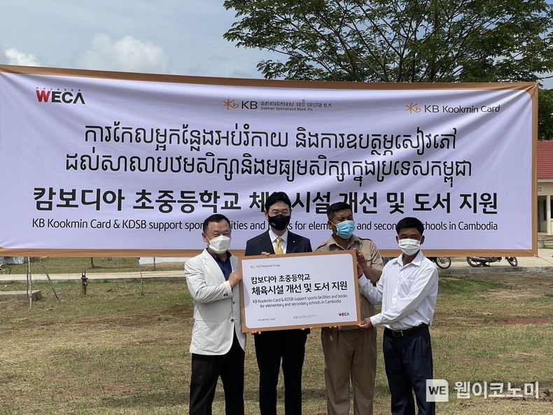 12일 캄보디아 칸달주 꼬레아루 초중등학교에서 열린 '캄보디아 초중등학교 체육시설 개선 및 도서지원' 기부금 전달식에서 이창권 KB국민카드 사장(왼쪽에서 두번째)이 행사에 참석한 관계자들과 기념촬영을 하고 있다. 2022.05.12 (출처 : KB국민카드)