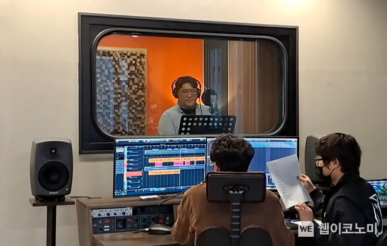 지난달 개최된 우리카드 ‘NU 그린콘서트’ 참여를 위해 사내 임직원 가수(가운데 헤드셋 착용)가 음원 녹음을 진행하고 있다. 2022.05.13 (출처 : 우리카드)