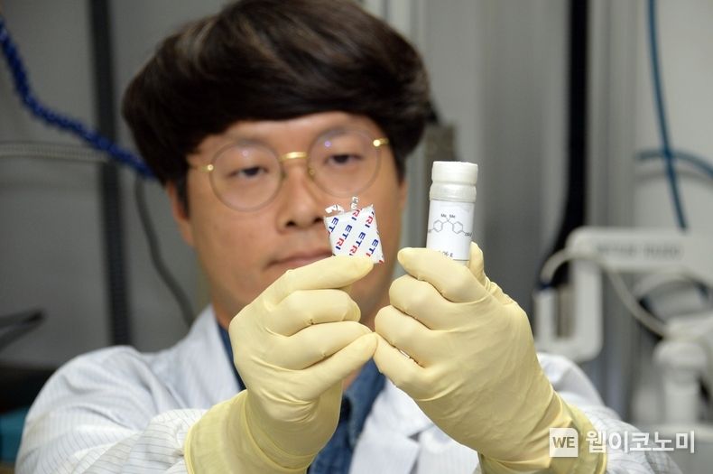 ETRI연구진이 불소화황산화물계 난연 첨가제(우측)와 첨가제가 적용된 리튬이차전지(좌측)를 관찰하는 모습 2022.10.20 (출처:ETRI)