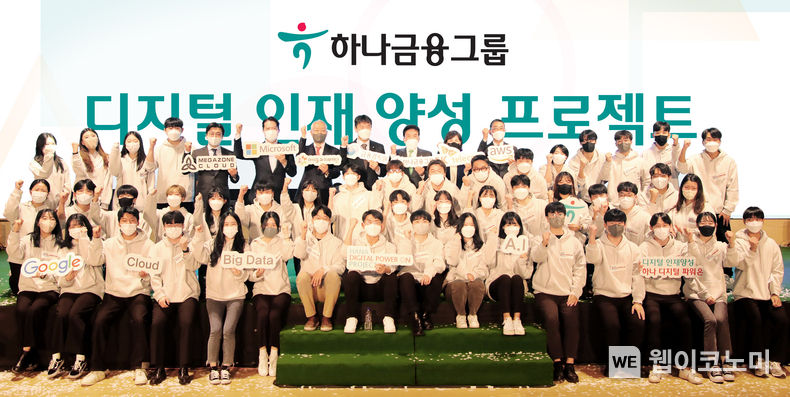 "하나금융그룹이 디지털 인재 양성을 위해 금융감독원과 손을 잡았다." 하나금융그룹은 27일 인천 청라 하나글로벌캠퍼스에서 디지털 인재 양성으로 대한민국 금융 혁신을 선도하기 위한 프로젝트 「하나 디지털 파워 온」 선포식을 개최하고, 이어서 프로젝트 최종 대상자 선발을 위한 「디지털 신기술 경진대회」를 실시했다. 이복현 금융감독원장(사진 맨 뒷줄 왼쪽에서 8번째)과 함영주 하나금융그룹 회장(사진 맨 뒷줄 왼쪽에서 9번째)이 이날 선포식에 참석한 내외빈 및 프로젝트에 지원한 학생들과 함께 파이팅을 외치며 기념 촬영을 하고 있다. 2022.10.27 (출처:하나은행)
