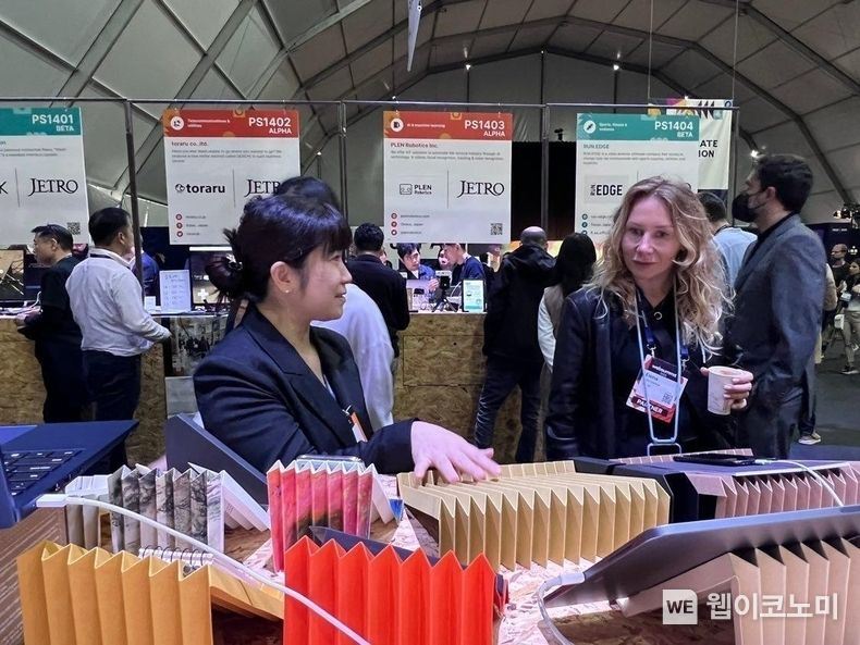 유럽 최대 기술 전시회 ‘웹서밋(Web Summit) 2022’에 참가한 친환경 소셜벤처 그레이프랩 김민양 대표(왼쪽)가 그레이프랩 전시 부스를 둘러보는 관람객에게 제품 설명을 하고 있다. 2022.11.09 (출처:SK이노베이션)