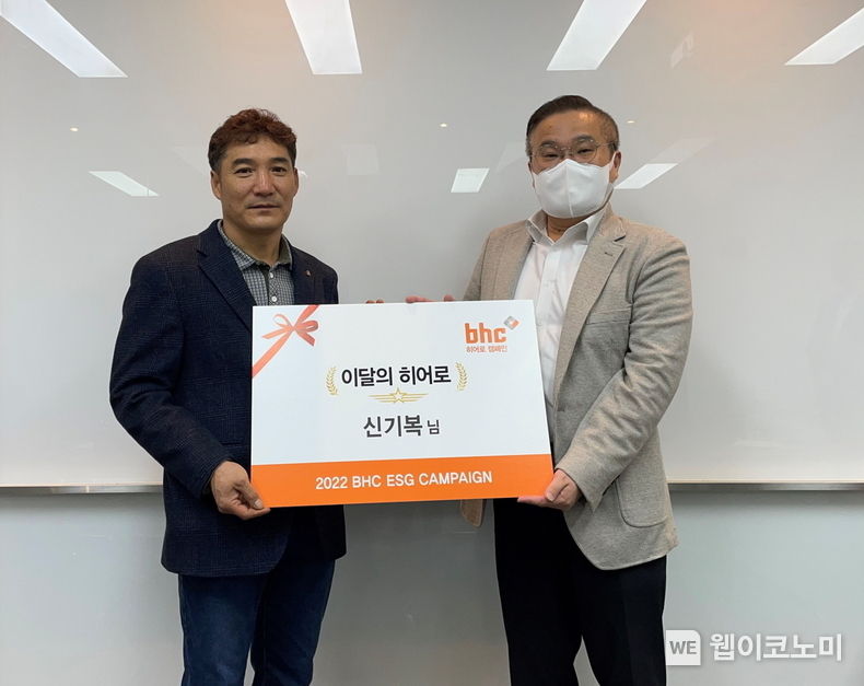 bhc그룹 SP/직영사업부 고병환 상무(우측)가 지난 28일 ‘bhc 히어로’로 선정된 신기복 씨(좌측)를 만나 상장과 치킨 상품권을 전했다. 2022.12.01 (출처:bhc그룹)