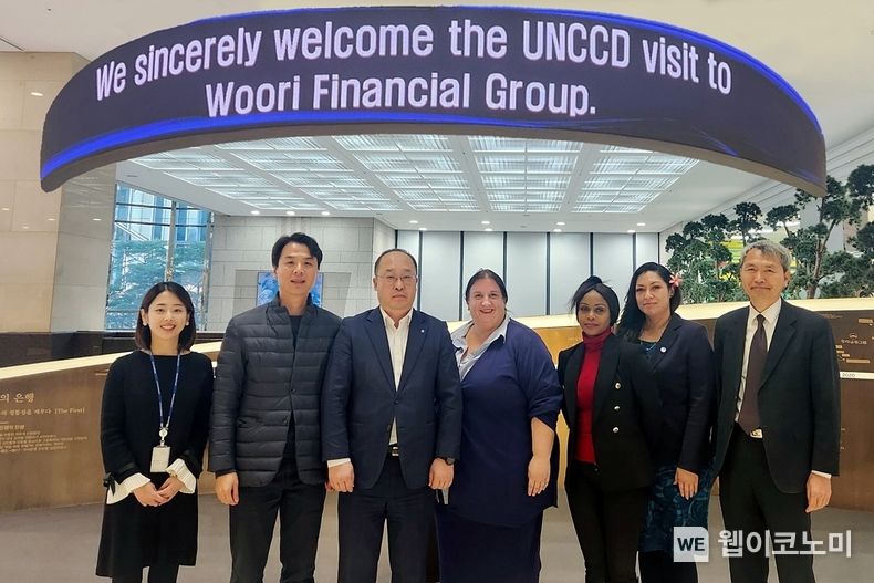 우리금융그룹(회장 손태승)은 서울시 중구 우리금융그룹 본사에서 UNCCD(유엔사막화방지협약) 방문단과 면담을 갖고, 글로벌 환경보전 및 ESG사업 분야의 국제적 협력방안에 대해 논의했다. UNCCD(유엔사막화방지협약) 루이스 베이커(Louise Baker) 디렉터(오른쪽 4번째)와 우리금융지주 ESG경영부 직원들(왼쪽 1,2,3번째)이 우리금융그룹 본사 '역사의 전당' 앞에서 기념좔영을 하고 있다. 2022.12.08 (출처:우리은행)