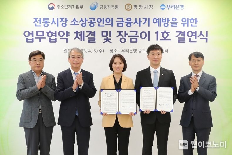 우리은행(은행장 이원덕)이 5일 광장시장 인근 소재 종로4가금융센터에서 광장시장과 ‘장금이 1호 결연’을 맺었다. 왼쪽부터 김영재 광장시장 상인총연합회 회장, 임종룡 우리금융그룹 회장, 이영 중소벤처기업부 장관, 이복현 금융감독원장, 정연기 우리은행 중소기업그룹 부행장이 기념촬영을 하고 있다. 2023.04.05 (출처 : 우리금융그룹)
