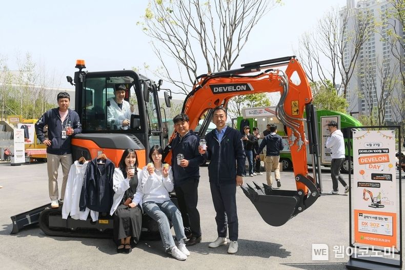 HD현대 임직원들이 판교 GRC에서 열린 ‘디벨론’ 출시 100일 기념 행사에서 전시된 디벨론 미니굴착기를 배경으로 기념촬영을 하고 있다. 2023.04.28 (출처 : HD현대인프라코어)