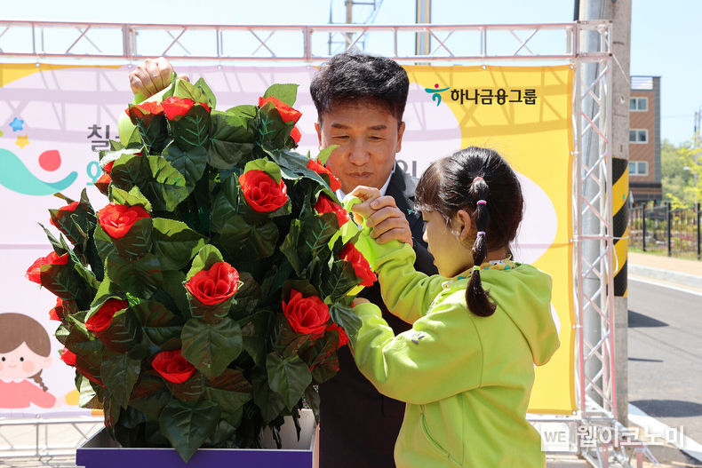 미래의 주인공인 아이들의 행복한 세상이 활짝 피기를 바란다는 의미로 함영주 하나금융그룹 회장(사진 왼쪽)과 칠곡 왜관하나어린이집의 원아가 화분에 물을 주자 꽃이 활짝 피고 있다. 2023.04.30 (출처: 하나금융그룹)
