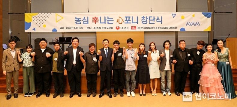 농심은 17일, 발달장애인 18명을 채용해 ‘농심 신(辛)나는 심(心)포니’를 창단했다. ‘농심 신나는 심포니 음악단’은 향후 전국의 학교와 사회복지시설, 지역 축제 및 농심 사내 행사 등에서 공연하며 장애인 인식개선 활동에 적극 나설 예정이다. 이병학 농심 대표이사(사진 왼쪽부터 7번째)는 단원들에게 입사명령서와 함께 배지를 직접 달아주며 농심가족이 된 것을 축하했다. 2023.05.18 (출처: 농심)