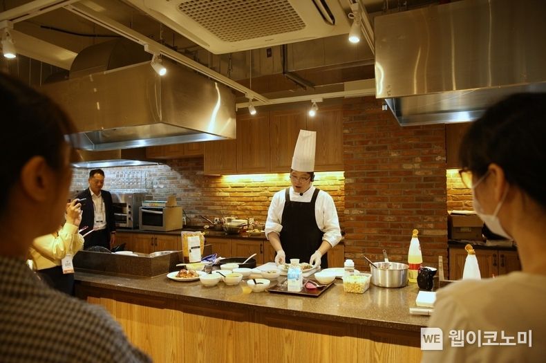  아워홈 동서울물류센터 내 쿠킹스튜디오에서 진행된 ‘간소화 식재 활용 정기 메뉴시연회’에서 아워홈 셰프가 프리미엄 메뉴 조리 과정을 고객에게 설명하고 있다. 2023.06.14 (출처 : 아워홈)