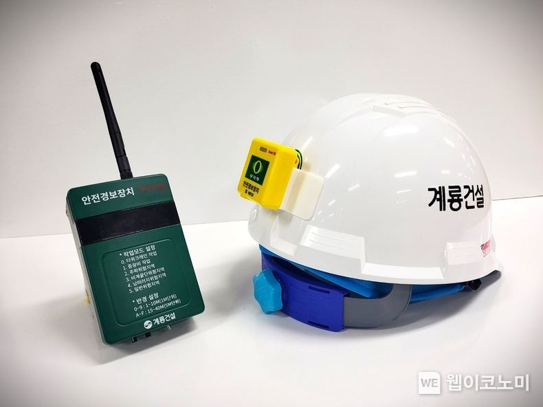 안전경보장치 송신기(왼쪽 초록색 기기)와 수신기(오른쪽 안전모에 부착된 노란색 기기) 2023.10.31 (출처: 계룡건설)