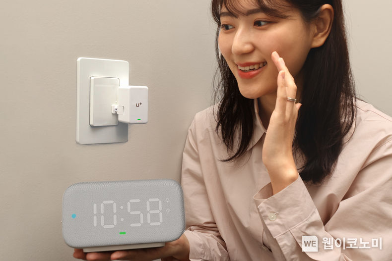 LG유플러스는 언제 어디서나 집안 조명과 히터 등 가전제품을 켜고 끌 수 있는 ‘U<sup>+</sup>스마트홈 버튼봇(이하 버튼봇)’을 출시한다고 21일 밝혔다. 사진은 LG유플러스 직원이 조명스위치에 장착된 ‘버튼봇’을 음성으로 제어하고 있는 모습. 2023.11.21 (출처: LG유플러스)