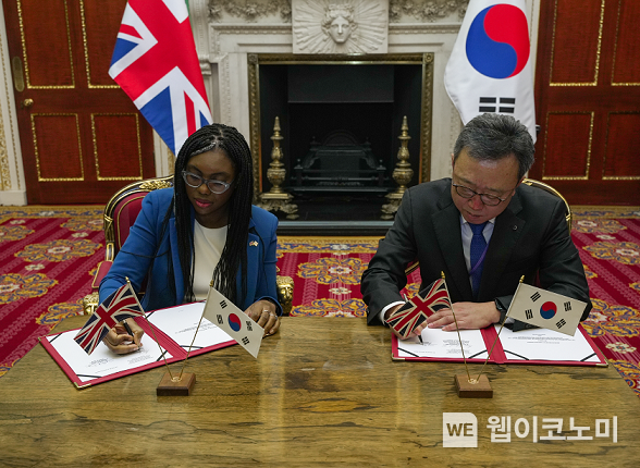 지난 22일 영국 런던 맨션하우스에서 진행된 업무협약식에서 영국 기업통상부 케미 베데노크 내각장관(왼쪽)과 신한은행 정상혁 은행장이 협약서에 서명하는 모습 / 2023.11.23 (출처: 신한은행)