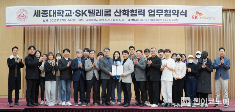 SK텔레콤이 세종대학교 메타버스융합대학원과 함께 글로벌 AI 및 미디어 콘텐츠 제작 패러다임 선도를 목표로 산학협력에 관한 업무협약을 27일 체결했다고 밝혔다. SKT 김혁 미디어제휴담당(사진 오른쪽서 14번째)과 세종대 엄종화 행정부총장(사진 왼쪽서 12번째) 등 양측의 주요 관계자들이 글로벌 AI 콘텐츠 인재 육성에 힘을 모을 것을 합의했다. / 2023.11.28 (출처: SK텔레콤)