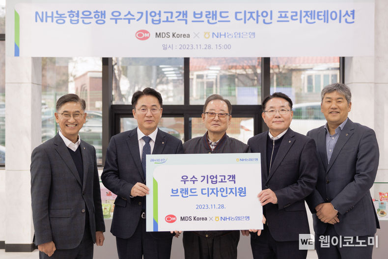 28일 경기 파주시 소재 MDS코리아에서 열린 브랜드 디자인 지원 현판식 행사에서 이석용 농협은행장(왼쪽 두번째), 문동준 MDS코리아 대표이사(가운데) 및 임직원들이 기념촬영을 하고 있다. / 2023.11.29. (출처: NH농협은행)