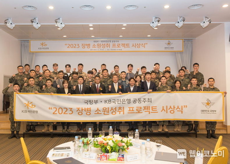 29일 서울시 용산구에 위치한 국방컨벤션에서 열린 ‘2023 장병소원성취 프로젝트’ 시상식에서 윤봉희 국방부 정책기획관(맨 앞 줄 좌측 6번째), 김동록 KB국민은행 기관고객그룹 대표(맨 앞 줄 좌측 7번째) 및 관계자들이 수상 장병들과 기념사진을 촬영하고 있다. / 2023.11.30 (출처: KB국민은행)