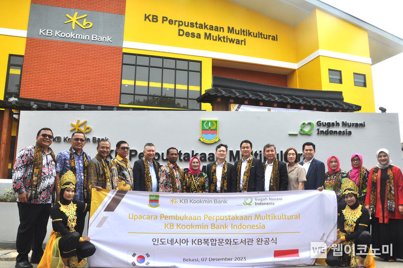 7일 인도네시아 버카시주 묵티와리 마을에서 진행된 'KB복합문화도서관 완공식'에서 로비 몬동 KB부코핀은행 수석부행장(좌측 5번째)과 김선 굿네이버스 국제사업본부장(좌측 9번째), 조용범 KB국민은행 ESG기획부장(좌측 8번째) 등 유관기관 관계자 및 지역 주민들이 기념사진을 촬영하고 있다.<br>
인도네시아 버카시주 'KB복합문화도서관' 완공식 진행 / 2023.12.08 (출처: KB국민은행)