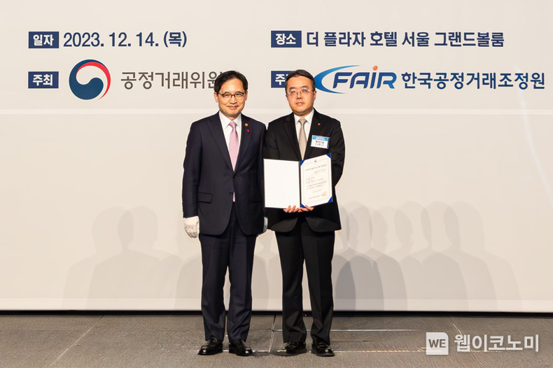 롯데건설 준법경영부문 조도휘 상무(사진 오른쪽)가 한기정 공정거래위원장(사진 왼쪽)으로부터 우수기업 평가증을 수여한 후 기념 촬영을 하고 있다 / 2023.12.18 (출처: 롯데건설)