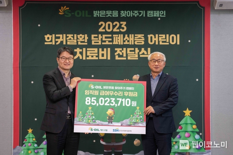 S-OIL 김광남 부문장(왼쪽)과 한국사회복지협의회 김홍중 사무총장(오른쪽)이 21일 서울 마포구 공덕동 본사에서 열린 저소득가정 담도폐쇄증 어린이 치료비 전달식에서 기념사진을 찍고 있다. / 2023.12.21 (출처: S-OIL)