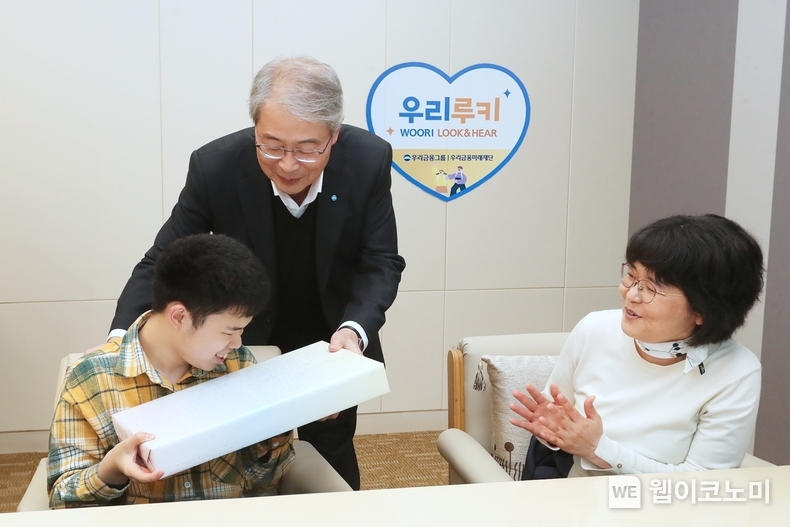 우리금융그룹 우리금융미래재단은 지난 2일 서울 중구에 있는 우리금융 본사에서 「우리 루키(Look & Hear) 프로젝트」를 통해 시·청각 수술비를 지원받은 수혜자와 가족 12명을 초청해 새해맞이 행사를 가졌다. 임종룡 우리금융그룹 임종룡 회장(가운데)이 초청 가족에게 선물을 전달하고 있다. / 2024.01.03 (출처: 우리금융그룹)