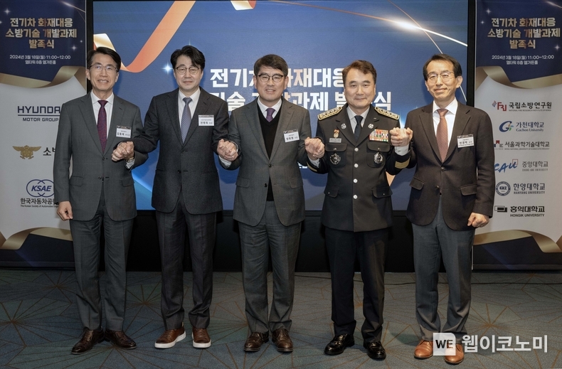 현대차∙기아, 첨단 소방기술 개발로 전기차 안전 높인다. 현대차∙기아는 18일(월) 서울시 서초구에 위치한 엘타워에서 현대차∙기아, 소방청(소방연구원), 한국자동차공학회 및 연구에 참여하는 5개 대학 관계자들이 참석한 가운데 ‘전기차 화재대응 소방기술 공동개발 협약’을 체결했다고 밝혔다. (사진) 체결식에서 기념사진을 찍는 모습 (좌측부터 현대차·기아 김동욱 부사장, 한국자동차공학회 전병욱 회장, 현대차·기아 양희원 사장, 소방청 남화영 청장, 전기차화재대응기술산학위원회 민경덕 위원 / 2024.03.18 (출처:현대차∙기아)