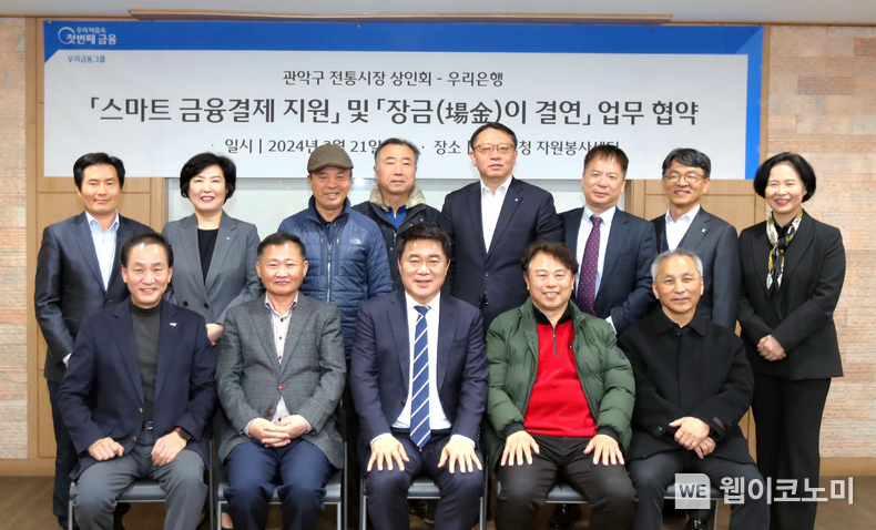 우리은행(은행장 조병규)이 지난 21일 관악구청 자원봉사센터에서 관악구 전통시장 상인회와 ‘스마트 금융결제 지원’ 과 ‘장금(場金)이 결연’ 업무협약을 체결했다. 관악구 전통시장 상인회 임영업 회장(앞줄 좌측 두번째), 박준희 관악구청장(앞줄 좌측 세번째), 우리은행 금융소비자보호그룹 정현옥 부행장(뒷줄 좌측 두번째), 우리은행 중소기업그룹 정진완 부행장(뒷줄 우측 네번째) 등 참석자들이 협약식에서 기념사진을 촬영하고 있다. / 2024.03.22 (출처: 우리은행)