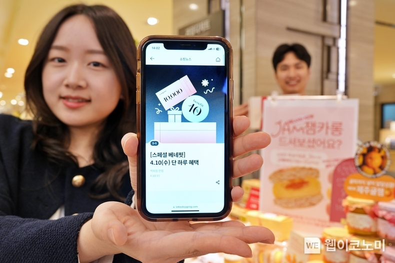  본점 식품관에서 '단 하루 쇼핑데이' 화면을 비추고 있는 모델 / 2024.04.08 (출처: 롯데쇼핑)