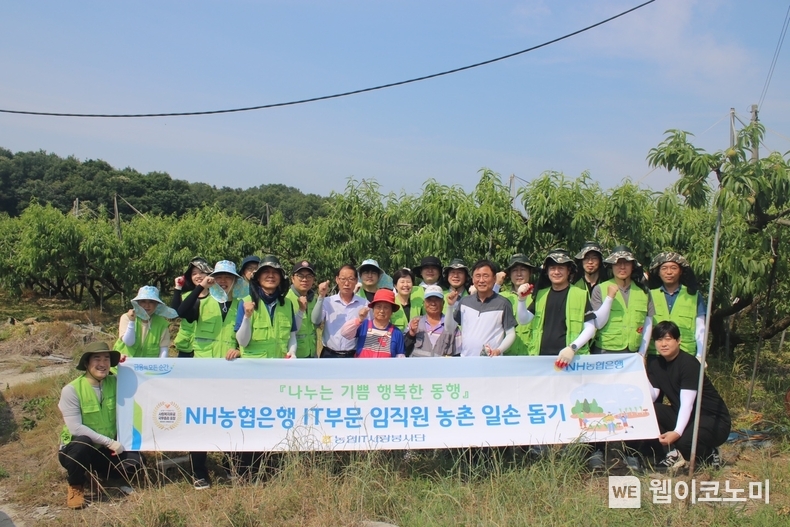 경기도 여주시 복숭아 농가에서 황재현 IT부문 부행장(플랜카드 잡고있는 사람 제외, 앞열 우측에서 네 번째) 및 직원들이 일손 돕기 행사후 기념사진을 촬영하고 있다. / 2024.06.10 (출처: NH농협은행)