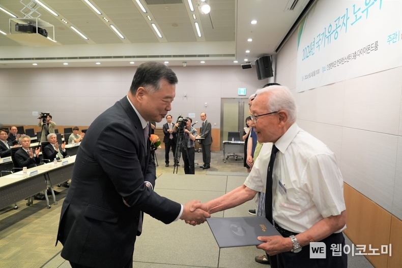 '2024년 국가유공자 노후주택보수 및 임차자금지원 기념식’에서 유병태 HUG 사장(왼쪽)이 6.25 참전 유공자(오른쪽)에게 기증서를 전달하고 있다. / 2024.06.26 (출처: 주택도시보증공사)