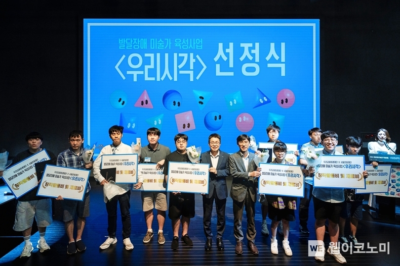 우리금융미래재단은 지난 2일 서울문화재단 청년예술청에서 발달장애 미술가 육성사업 ‘우리시각’ 선정식을 가졌다. 선정작가 10명이 서울문화재단 이창기 대표이사(왼쪽에서 6번째), 우리금융미래재단 박준태 사무국장(왼쪽에서 7번째)과 기념사진 촬영을 하고 있다. / 2024.07.03 (출처: 우리금융그룹)