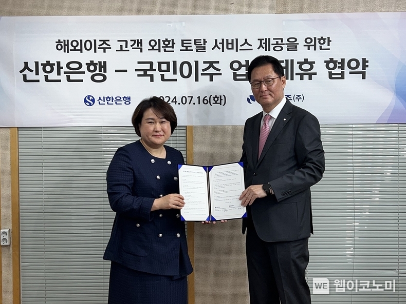 지난 16일 서울시 강남구에 위치한 국민이주㈜ 본사에서 진행된 ‘해외이주 고객 외환 토탈 서비스 제공을 위한 업무 협약식’에서 신한은행 이해창 외환본부장(오른쪽)이 국민이주㈜ 김지영 대표이사(왼쪽)와 기념촬영 하는 모습 / 2024.07.17 (출처: 신한은행)