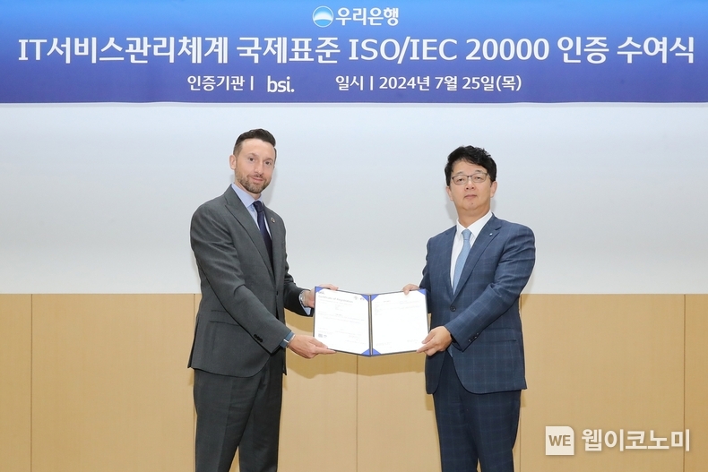우리금융디지털타워 우리금융홀에서 우리은행 조한래 부행장(오른쪽)과 BSI그룹 보증서비스대표(Assurance Service President) 해롤드 프래달(Harold Pradal)이 ISO 20000 인증 수여식에 참석해 기념촬영을 하고 있다. / 2024.07.25 (출처 : 우리은행)