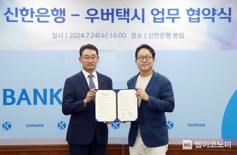 지난 24일 서울시 중구 소재 신한은행 본점에서 진행된 우버 택시와 가맹기사 금융솔루션 제공을 위한 업무협약식에서 신한은행 김광수 고객솔루션그룹장(왼쪽)과 우버 택시 송진우 대표이사가 기념촬영하는 모습 / 2024.07.25 (출처 : 신한은행)