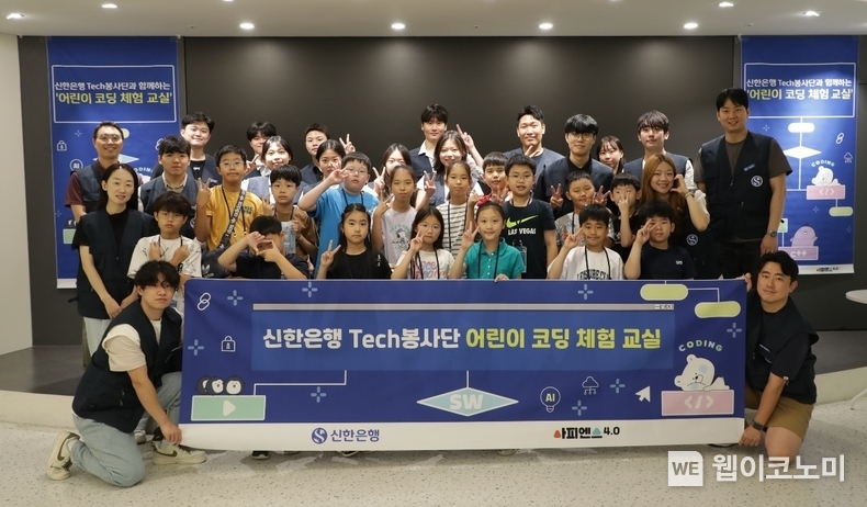 지난 27일 서울시 중구 소재 명동 익스페이스에서 ‘어린이 코딩 체험 교실’을 진행하고 ‘Tech 봉사단’ 직원들이 참여 학생들과 기념촬영하는 모습 / 2024.07.29(출처 : 신한은행)