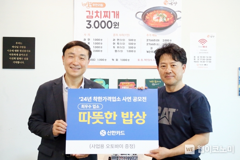 신한카드(사장 문동권)는 착한가격업소 사연 공모전을 통해 전국 9곳의 우수 업소를 선정했다고 18일 밝혔다. 16일 오후 문동권 신한카드 대표이사 사장(왼쪽)이 최우수 업소로 선정된 서울 은평구 소재 '따뜻한 밥상(연신내점)'을 방문해 사업용 오토바이 경품을 전달한 후 업주와 기념 촬영을 하고 있다. / 2024.08.19 (출처: 신한카드)