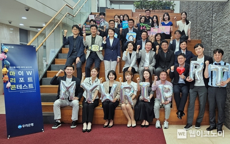 우리은행이 고객 중심 자산관리와 포트폴리오 영업문화 조성을 위해 전 직원이 참여하는 ‘2024 마이 W 리포트 콘테스트’를 개최한다. 콘테스트에 참여한 직원들과 우리은행 송현주 자산관리그룹장(두번째 줄 왼쪽에서 세번째)이 기념사진을 촬영하고 있다. / 2024.08.23 (출처: 우리은행)