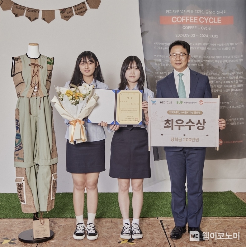 3일 성동구 '서울새활용플라자'에서 SPC행복한재단이 진행한 '커피자루 업사이클 디자인 공모전 시상식'에서 SPC행복한재단 백승훈 사무국장(오른쪽)과 최우수상을 수상한 인천생활과학고등학교 양예주(가운데), 장아영(왼쪽) 학생이 수상작 옆에서 기념촬영을 하고있다. / 2024.09.04 (출처: SPC)